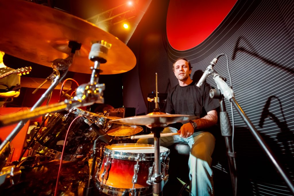 Drummer playing on drum set on stage.